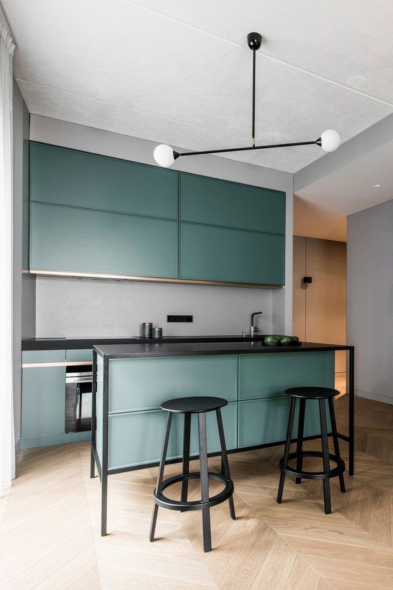 The kitchen features sleek green cabinets, a grey backsplash, a .