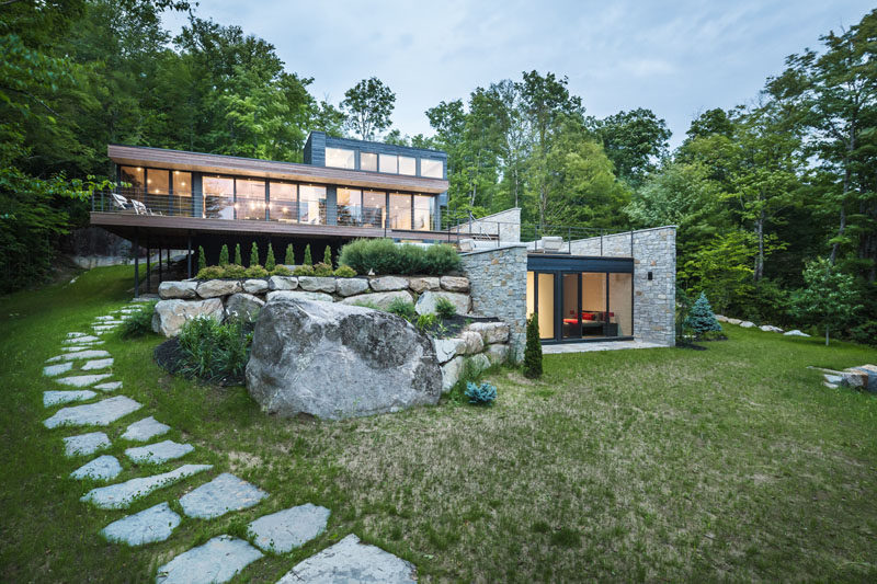 Wood And Stone Cover The Exterior Of This Multi-Level Modern House .