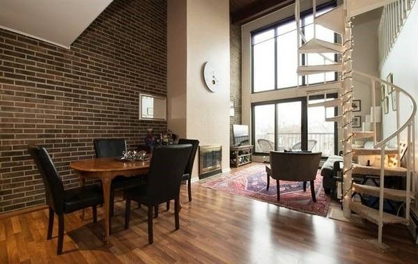 Contemporary loft apartment with exposed brick, wood burning .