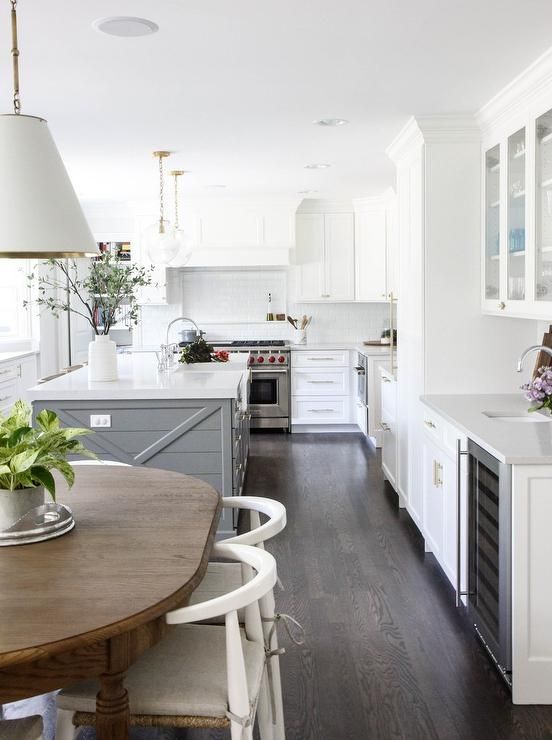 U-shaped white and gray kitchen boasts dark stained oak floor .