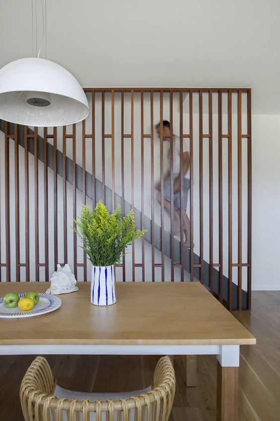 modern wooden screen to cover the staircase and make the dining .