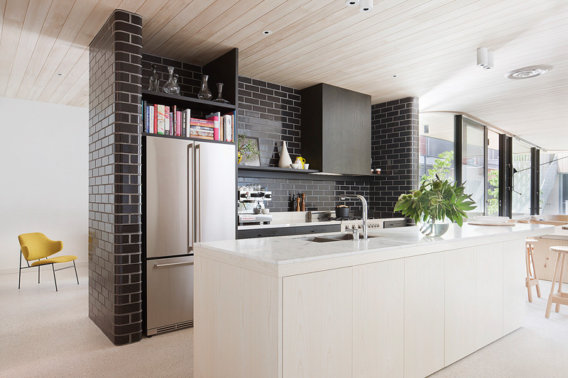 A central wall of glazed bricks forms the kitchen in this .