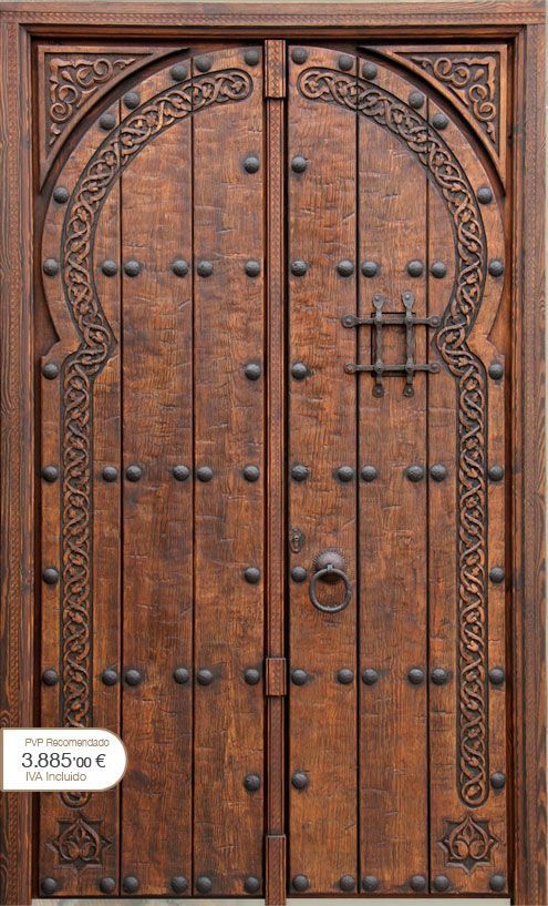 Beautiful wooden entrance door with engraving and iron studs .