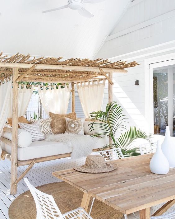 a welcoming tropical terrace with a wooden table, white metal .