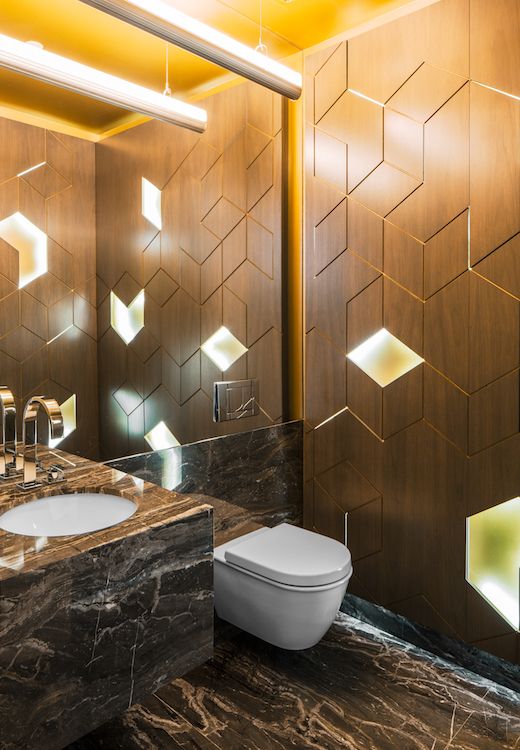 Geometric walnut tiles give this powder room a futuristic look .
