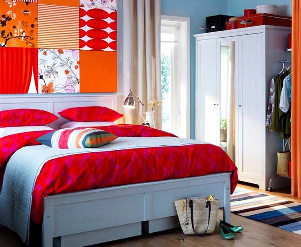 blue wall paint and bedding with red and orange wall decor .