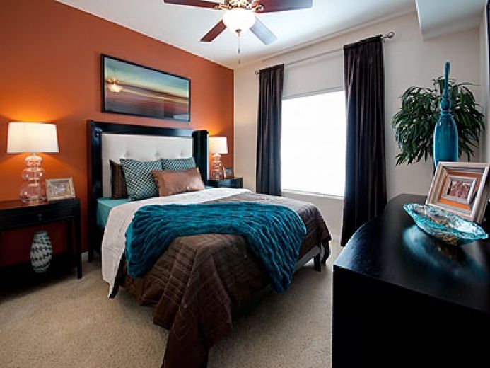 Love this room!!! The orange accent wall with teal and brown .