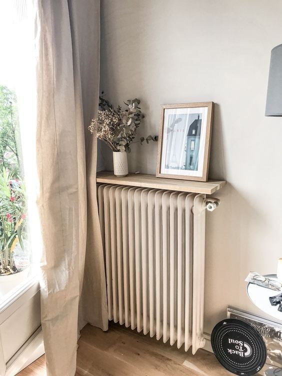 a neutral radiator matching the wall and a matching shelf with decor are a lovely way to make it almost invisible