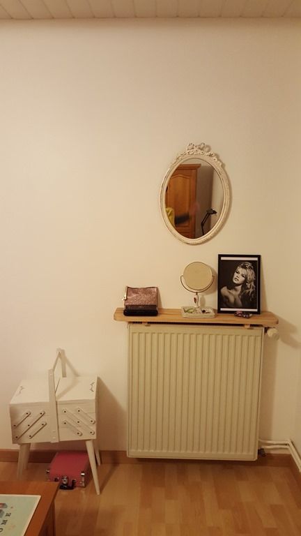 a small radiator covered with a shelf and some decor is a cool idea for any space