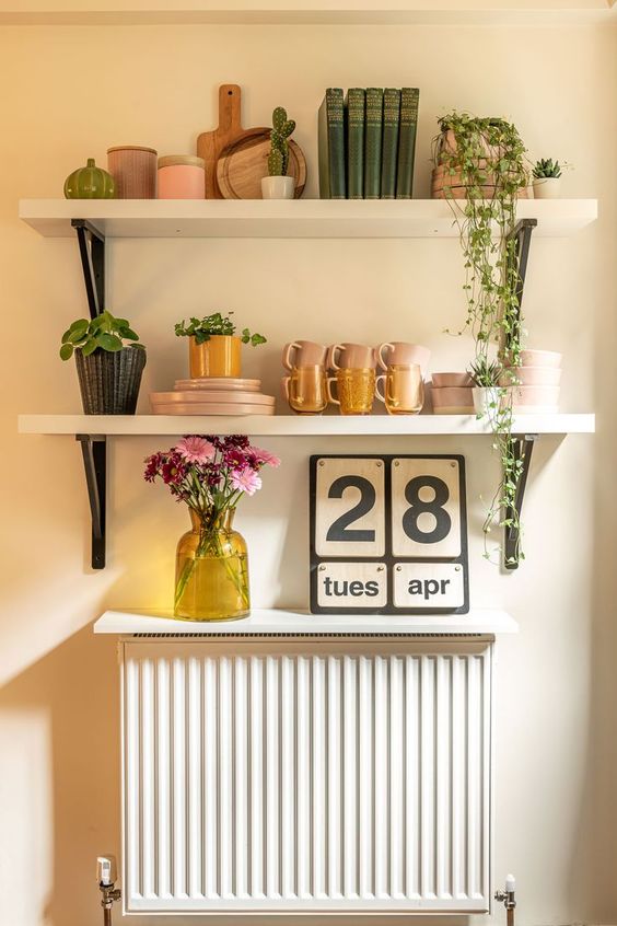 a small radiator with a small white shelf that matches the shelves over them, this way the radiator becomes part of decor
