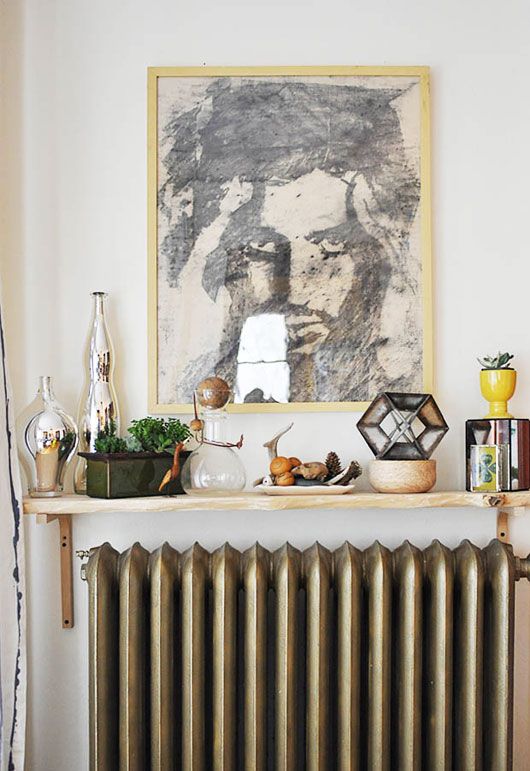 a small shelf over the radiator and lots of things displayed on this shelf are so eye-catchy that no one sees the radiator itself