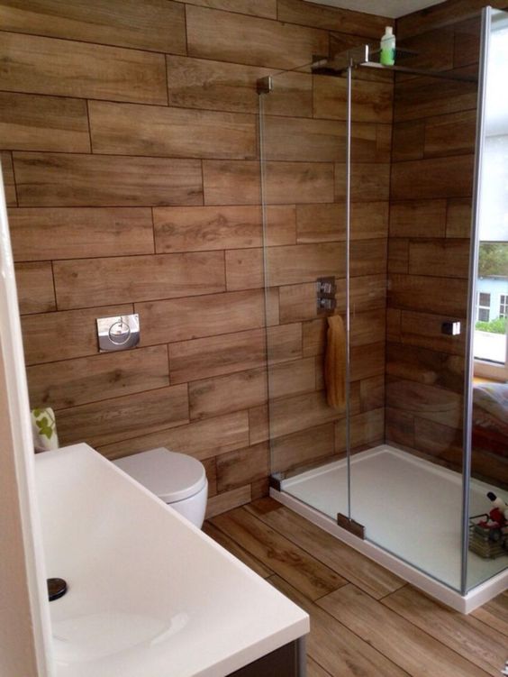 a contemporary rustic bathroom all clad with wood look tiles - the walls and the floor for a warm feel