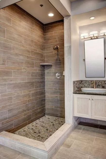 a rustic bathroom with wood look tiles, neutral ones on the floor and mosaic tiles for accents here and there