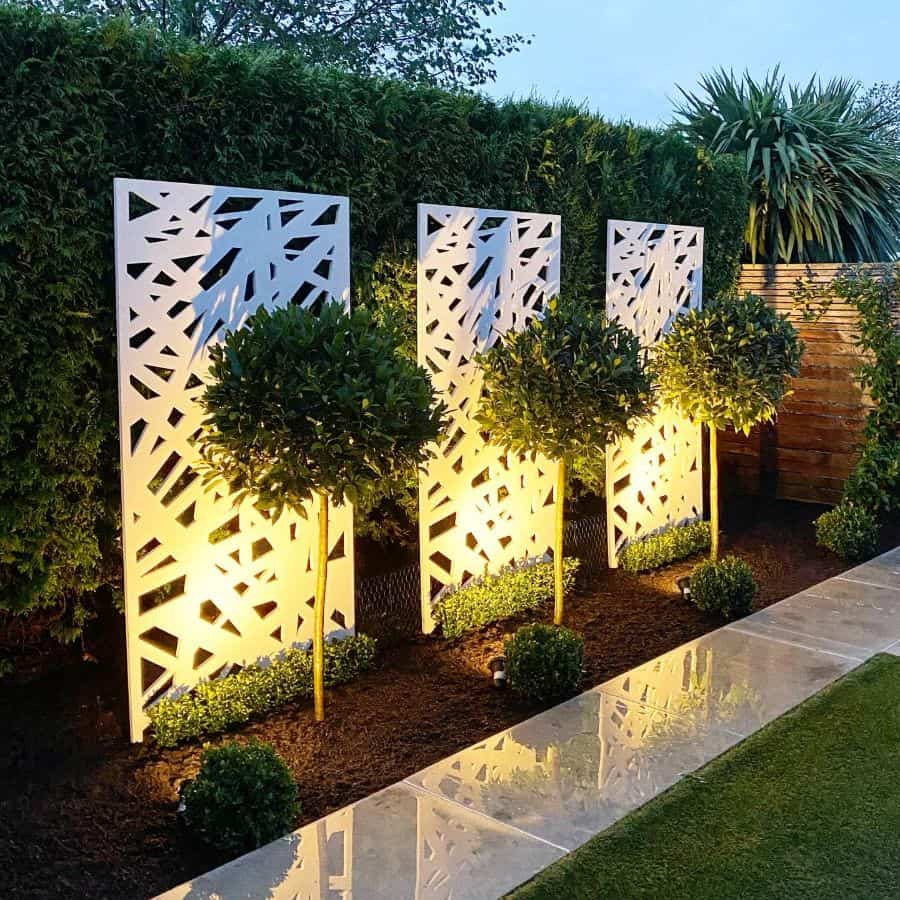 Modern backyard path made of gray slate, white partitions with lights