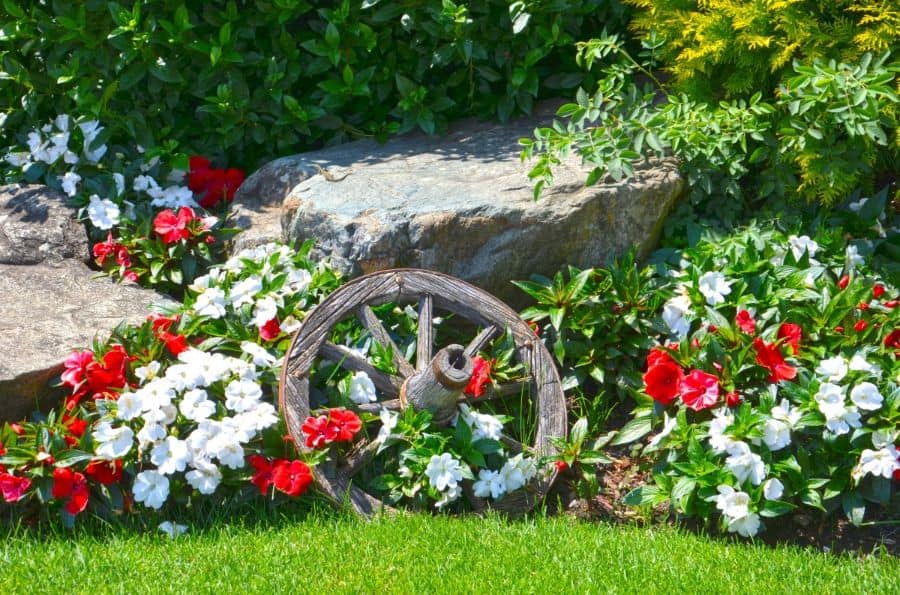 Carriage wheel garden with white and red flower stones 