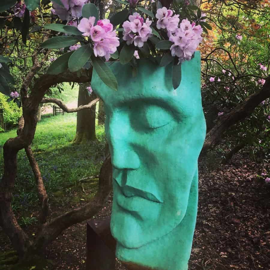 Garden statue with blue face and flowers on head