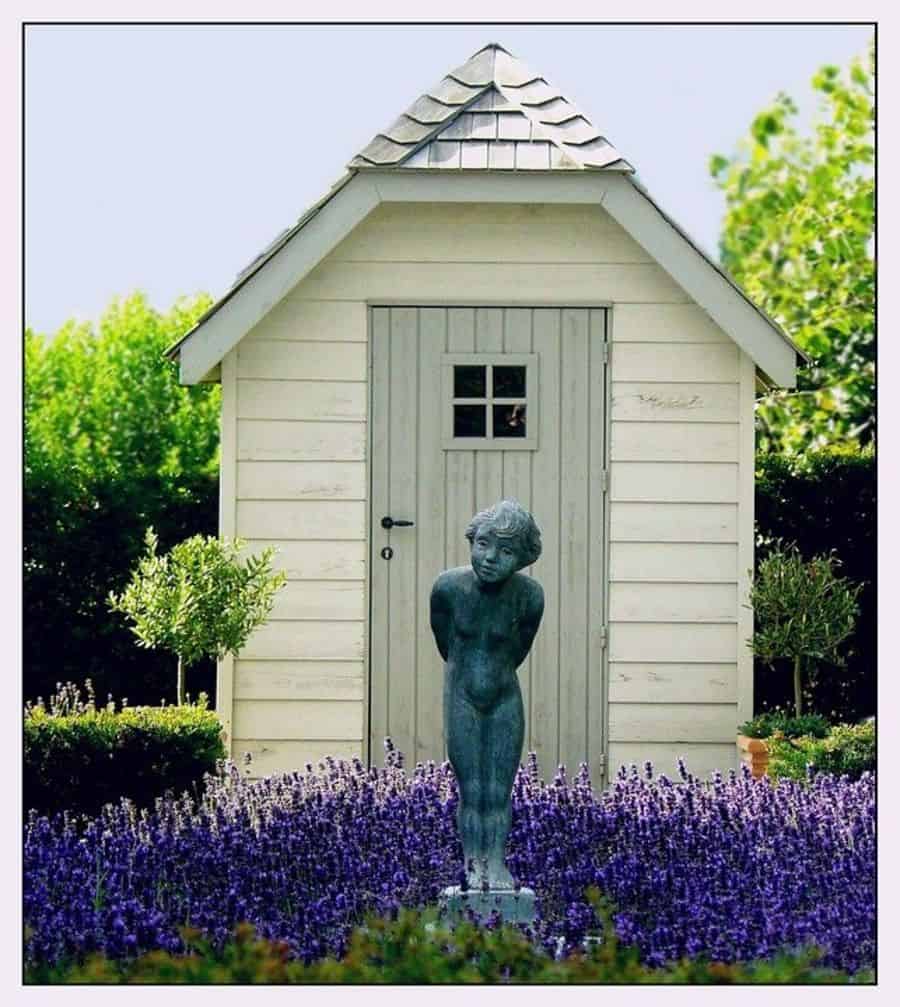 small white wooden shed, blue woman, garden statue, lavender 