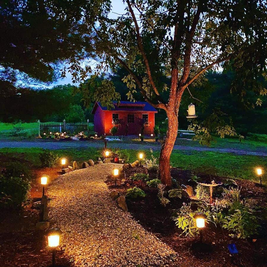 Large red shed in the backyard, gravel path, garden lighting 